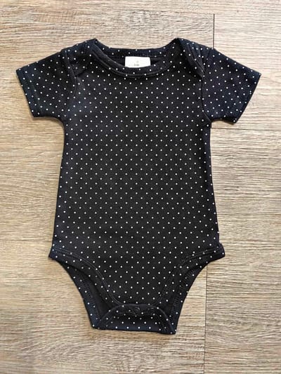 Détail body bébé noir fleuri en 100 % coton