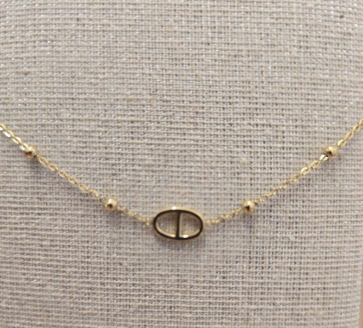 Détail du bracelet femme perles dorées et pendentif ovale