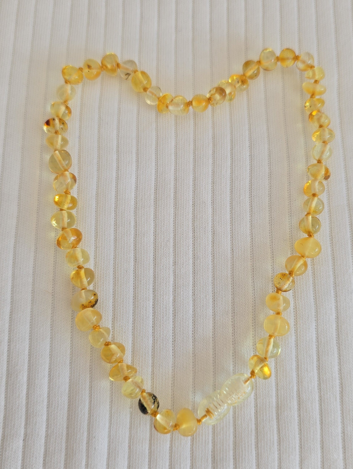 Détail collier bébé en ambre naturel de la Baltique