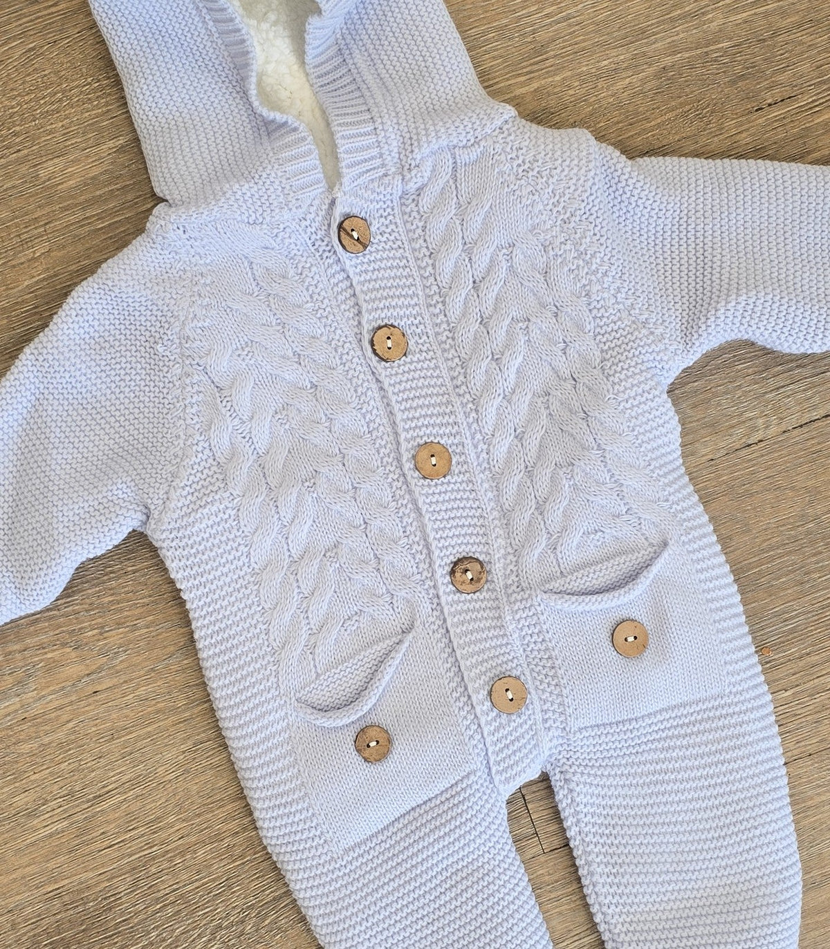 Détail combinaison bébé bleue en laine tailles 6, 9 et 12 mois