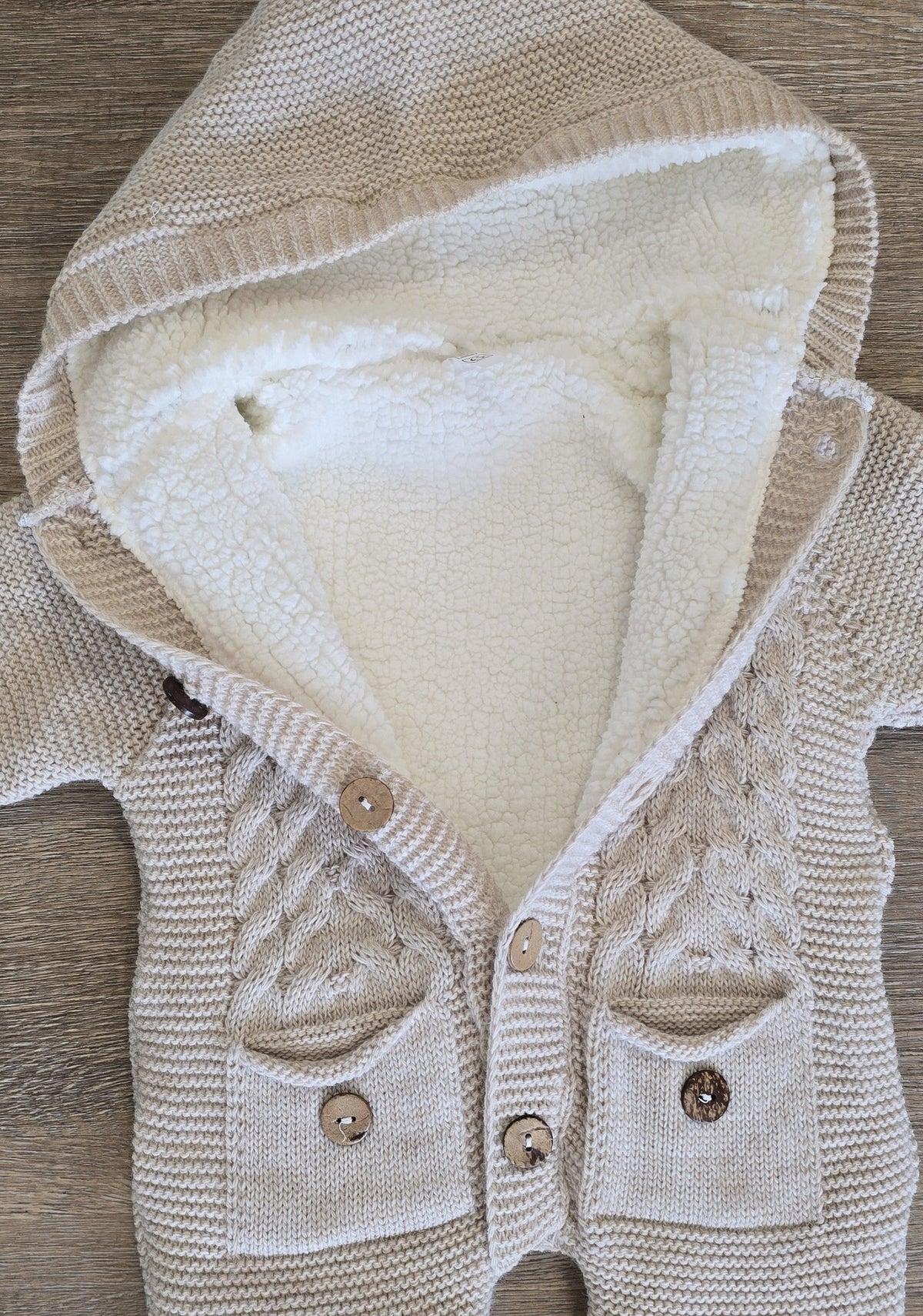 Détail boutons et maille torsadée de la combinaison bébé marron en laine