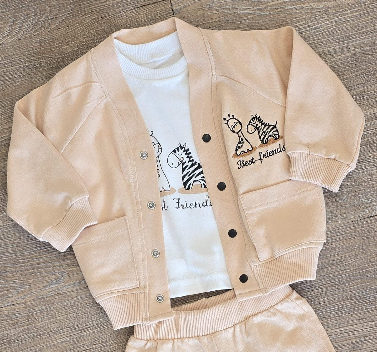 Détail de l’ensemble bébé garçon beige 3 pièces avec t-shirt écru