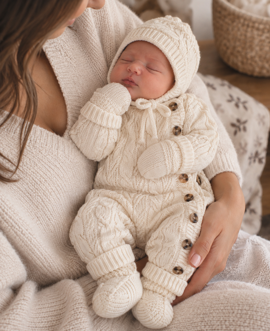 Bébé portant le kit 4 pièces avec combinaison, bonnet, gants et chaussettes