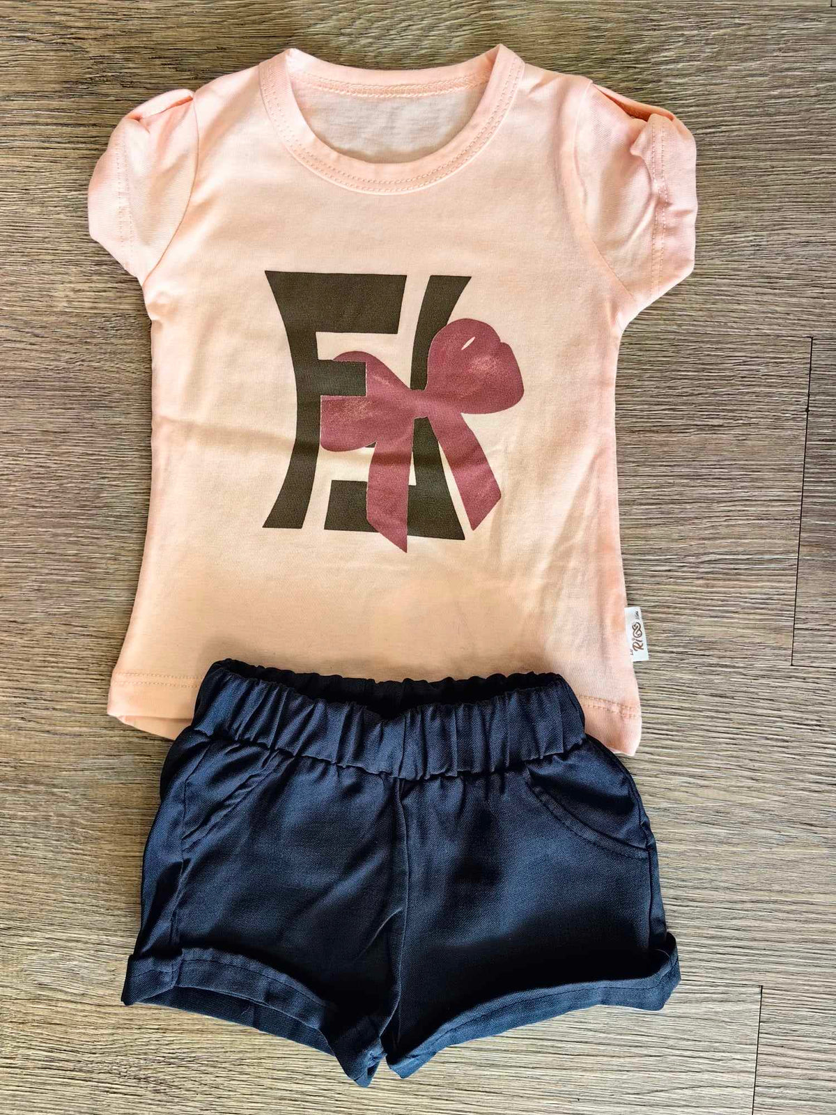 Tee-shirt rose poudré à imprimé graphique et short bleu marine bébé fille